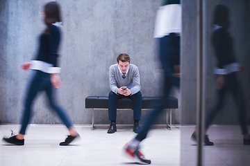 Image showing businessman using mobile phone while sitting on the bench