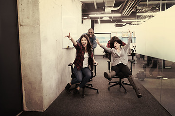 Image showing multiethnics business team racing on office chairs