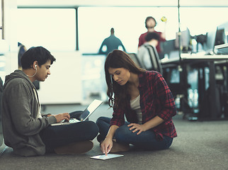 Image showing young software developers couple working on the floor