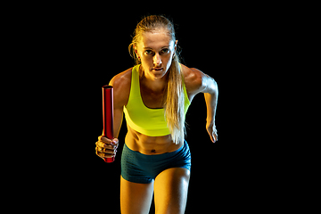 Image showing Professional female relay racer training on black studio background in neon light