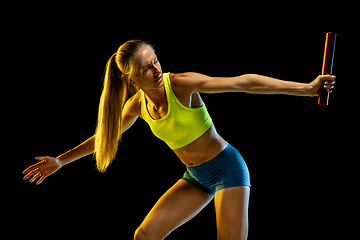 Image showing Professional female relay racer training on black studio background in neon light