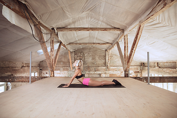 Image showing A young athletic woman working out on an abandoned construction site