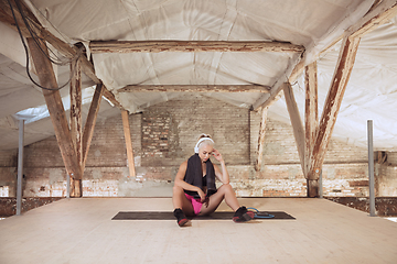 Image showing A young athletic woman working out on an abandoned construction site