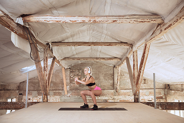 Image showing A young athletic woman working out on an abandoned construction site