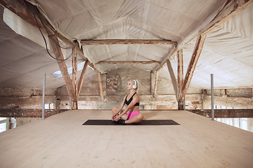 Image showing A young athletic woman working out on an abandoned construction site