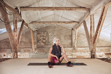 Image showing A young athletic woman working out on an abandoned construction site