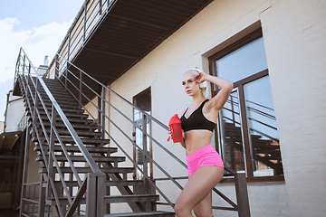 Image showing A young athletic woman working out on a stairs outdoors