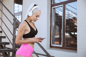 Image showing A young athletic woman working out on a stairs outdoors