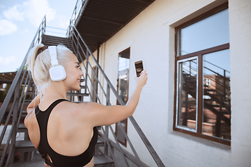 Image showing A young athletic woman working out on a stairs outdoors