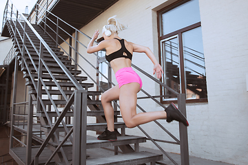 Image showing A young athletic woman working out on a stairs outdoors