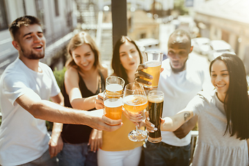 Image showing Young group of friends drinking beer and celebrating together