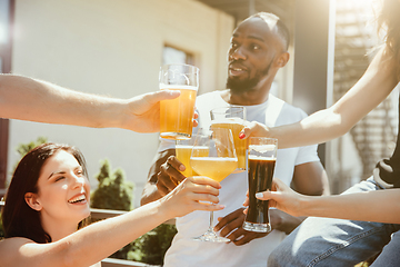 Image showing Young group of friends drinking beer and celebrating together