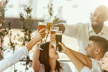 Image showing Young group of friends drinking beer and celebrating together