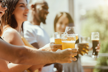 Image showing Young group of friends drinking beer and celebrating together