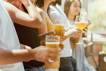 Image showing Young group of friends drinking beer and celebrating together