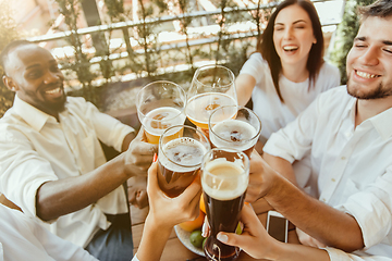 Image showing Young group of friends drinking beer and celebrating together