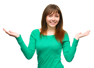 Image showing Portrait of a young woman raised her hands up