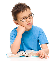 Image showing Little boy is tired to read his book