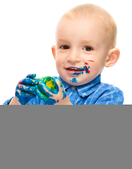 Image showing Little boy is playing with paints