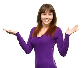 Image showing Portrait of a young woman raised her hands up