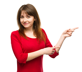 Image showing Portrait of a young woman pointing to the right