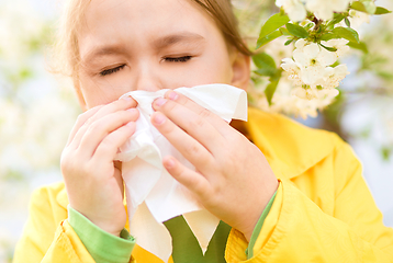 Image showing Little girl is blowing her nose