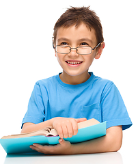 Image showing Little boy is reading a book