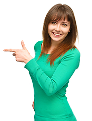 Image showing Portrait of a young woman pointing to the left