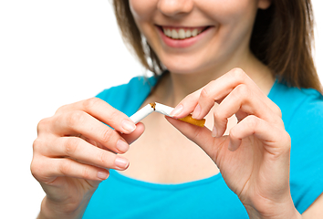 Image showing Young woman is breaking a cigarette