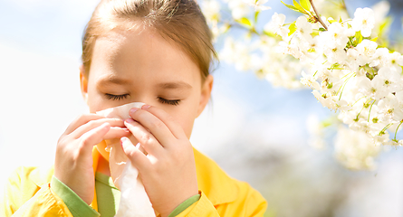 Image showing Little girl is blowing her nose