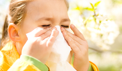 Image showing Little girl is blowing her nose