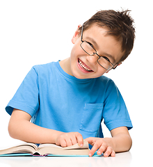 Image showing Little boy is reading a book