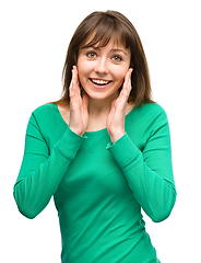 Image showing Woman is holding her face in astonishment