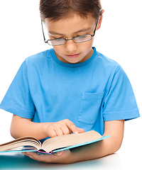 Image showing Little boy is reading a book