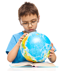 Image showing Little boy is examining globe