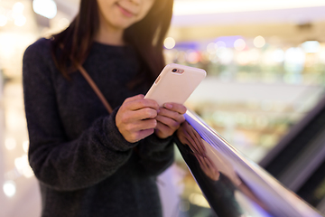 Image showing Young Woman sending text message in mobile phone