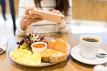 Image showing Woman taking photo with cellphone in restaurant