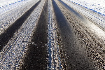 Image showing part of the snow-covered asphalt road close up