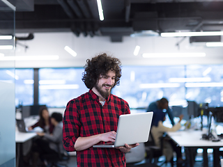 Image showing smiling male software developer using laptop