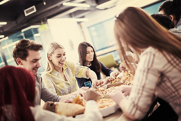 Image showing multiethnic business team eating pizza