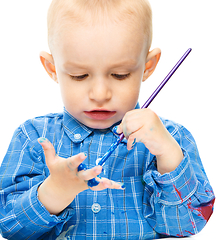 Image showing Little boy is playing with paints