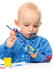 Image showing Little boy is playing with paints