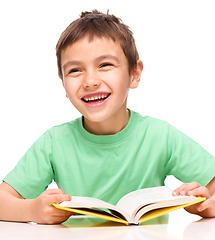 Image showing Little boy plays with book