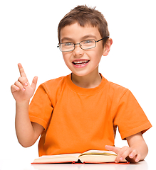 Image showing Little boy is reading a book