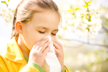 Image showing Little girl is blowing her nose