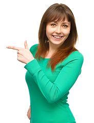 Image showing Portrait of a young woman pointing to the left