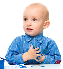 Image showing Little boy is playing with paints