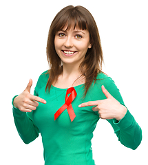 Image showing Woman is pointing to the red awareness ribbon