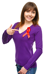 Image showing Woman is pointing to the red awareness ribbon