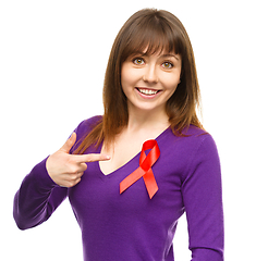 Image showing Woman is pointing to the red awareness ribbon